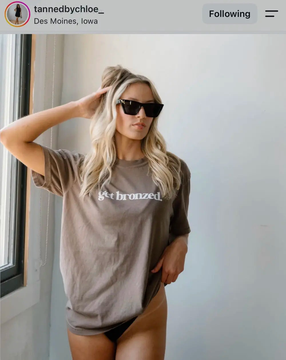 Spray tan artist wearing a Get Bronzed shirt