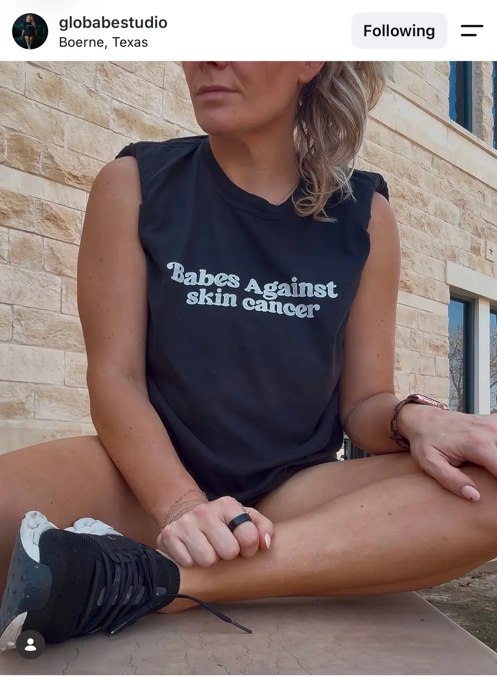 Spray tan artist wearing a Babes Against Skin Cancer tank